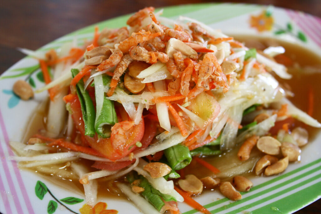 salade de papaye thaïlandaise Som Tam en gros plan dans une assiette