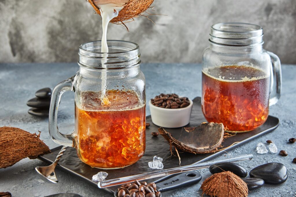 Café glacé thaïlandais au lait de coco avec de la glace pilée dans un bocal Mason Jar.